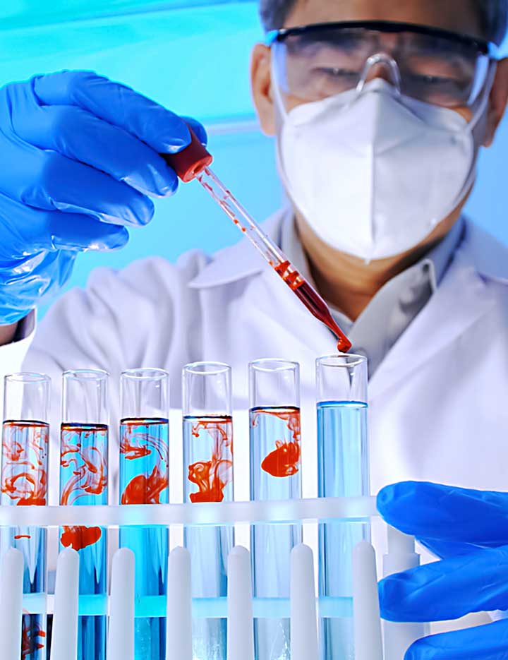 Scientist working with red chemicals in test tubes in a lab setting