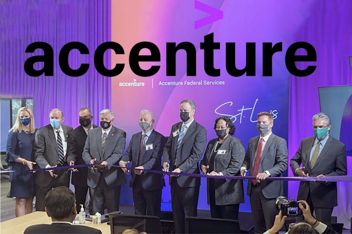 A group of business people cut a ribbon on stage with the accenture logo displayed behind them