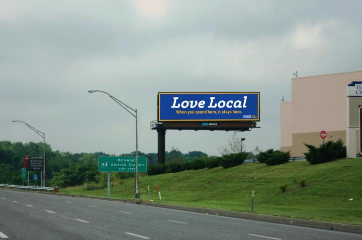Royal blue billboard in St. Louis that reads Love Local: "When you spend here, it stays here."