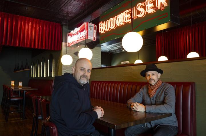 Two members of the Garcia family sit, looking at the camera, in one of their restaurants